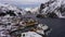 Nusfjord Fishing Village and Mountains in Winter. Lofoten Islands, Norway. Aerial View