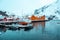 Nusfjord, small fishing village in Norway, during amazing winter evening, ships, snow and yellow cabins.