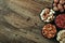 Nut mix of cashews, pistachios, almonds, macadamia, walnuts in bowls on wooden table with empty space, food blog photo