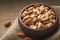 Nut mix in wooden cup Macro, burlap fabric background, top view