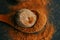 Nutmeg in a cut and nutmeg powder in a wooden spoon on a black slate background.condiments and spices background.