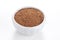 Nutmeg powder in a bowl on white background.