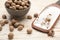 Nutmeg seeds, bowl and hand grater on white wooden table, closeup