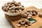 Nutmeg seeds and green leaf on white wooden table, closeup