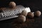 Nutmeg seeds and hand grater on black table, closeup