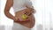 Nutrition and diet during pregnancy, woman with baby in belly keeps in hand green apple