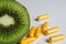 Nutritional vitamins supplement concept: Macro close up of isolated half sliced fresh ripe green kiwifruit with yellow capsules