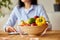 Nutritionist, dietitian woman writing a diet plan, with healthy vegetables and fruits