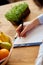 Nutritionist, dietitian woman writing a diet plan, with healthy vegetables and fruits