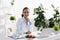 Nutritionist in white coat near vegetables and laptop
