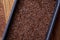 Nutritious flaxseed on baking tray over wooden background, selective focus, shallow depth of field.