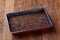 Nutritious flaxseed on baking tray over wooden background, selective focus, shallow depth of field.