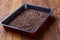Nutritious flaxseed on baking tray over wooden background, selective focus, shallow depth of field.
