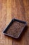 Nutritious flaxseed on baking tray over wooden background, selective focus, shallow depth of field.