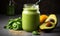 Nutritious green smoothie in glass jar with spinach leaves, half avocado, and chia seeds on grey backdrop - a healthful vegan