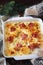 Nutritious winter dish. Potato gratin with bacon in hands