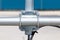 Nuts clamp aluminum cable duct electric wire small. Blurred blue concrete wall background.