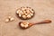 Nuts pistachios in a wooden spoon and a brown earthenware plate on old burlap