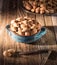 Nuts, whole almonds in a handmade vintage bowl on a wooden rustic background. In the dawn sunlight.