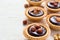 Nutty chocolate dessert small tarts on a white background, space