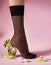 Nylons, stay-up, tights, hosiery, hose, pantyhose socks summer collection on pink background as a heel creative a glass of
