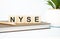 nyse word written on wooden cubes with copy space