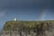 O`Brien`s Tower and colorful rainbow in blue sky. Cliff of Moher, Ireland. Famous travel destination. Irish luck concept