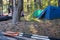 Oars lie on an overturned kayak on the shore, in the camp, against the backdrop of a tent and forest. Tourism and active