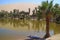 The oasis lagoon at Huacachina village surrounded by many palm trees with sand dune in background, Ica, Peru, South America