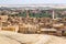 Oasis with ruins. Ancient middle eastern Arab town built of mud bricks, old mosque, minaret. New city in back. Al Qasr, Dakhla,