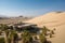 oasis surrounded by towering dunes and desert landscape