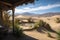 oasis surrounded by view of rolling sand dunes and distant mountains