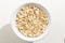 Oat cereal grain. Top view of grains in a bowl. White background