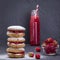 Oat cookies with raspberry, soft cheese, honey and raw raspberry and red juice on the background of black slate , close up