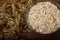 Oat ears stems and oat flakes in a bowl on a dark brown wood background. oatmeal flakes coarse. large-sized flakes. Close up. Usef