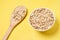 Oat flakes. Healthy eating. Wooden spoon. Yellow background