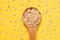 Oat flakes. Healthy eating. Wooden spoon. Yellow bright background