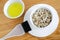 Oat flakes and olive oil in a small ceramic bowls for preparing natural masks and scrubs. Ingredients for homemade cosmetics.