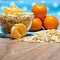 Oat flakes scattered on the table and in a glass bowl and tangerines