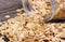 Oat flakes spilling out of jar on wooden background