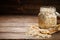 Oat flakes uncooked in a glass jar on wooden background.