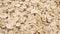 Oat flakes. Uncooked oatmeal. Rolled whole grains. Macro. Slow rotation.