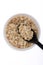 Oat flakes, uncooked oats in bowl with poon and wheat ears on white background. Concept of healthy eating, vegan food, healthy foo