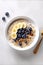 Oat porridge with banana, blueberry, walnut, milk for healthy breakfast