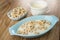 Oat rings in bowl, jug with yogurt, oat rings in blue bowl with yogurt on table