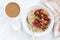 Oatmeal with baked fruit and fresh coffee with milk, top view