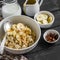 Oatmeal with banana, caramel sauce and pecan nuts in a white bowl on a dark wooden surface