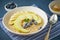 Oatmeal with bananas, blueberries, jam, honey, blue napkin on blue stone background. Close-up, side view