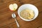 Oatmeal in bowl with apple and spoon on table
