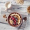 Oatmeal in bowl with berries, bananas and walnuts